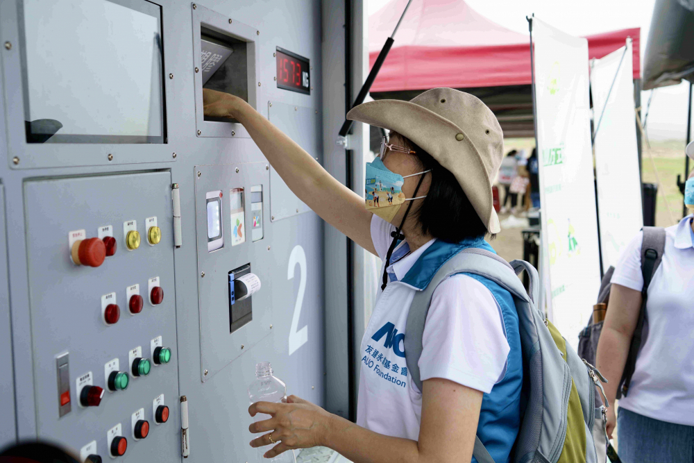 志工們將拾起的寶特瓶投入「好歸塑專車」，讓廢棄塑料空瓶可以直接粉碎、縮小體積，未來將可再製成購物袋、寶特衣、悠遊卡等生活用品